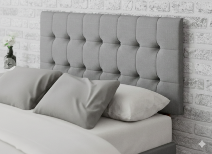 Modern grey tufted upholstered headboard with comfortable white mattress and pillows in a stylish bedroom setting